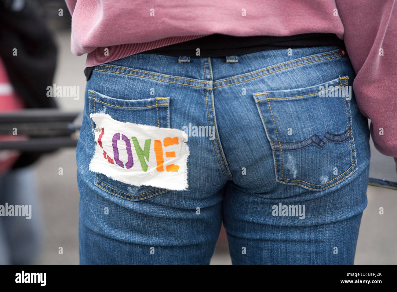 Donna con la parola 'amore' sul retro dei jeans Foto Stock