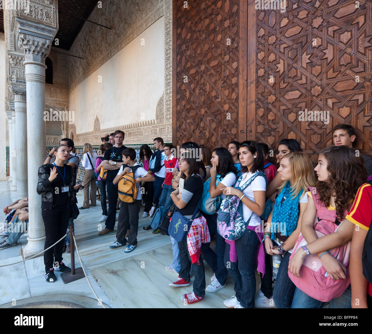 Insegnante di spagnolo e la scuola dei bambini touring la Corte dei Mirti (il Patio de Comares), Alhambra Palace, Granada, Spagna Foto Stock