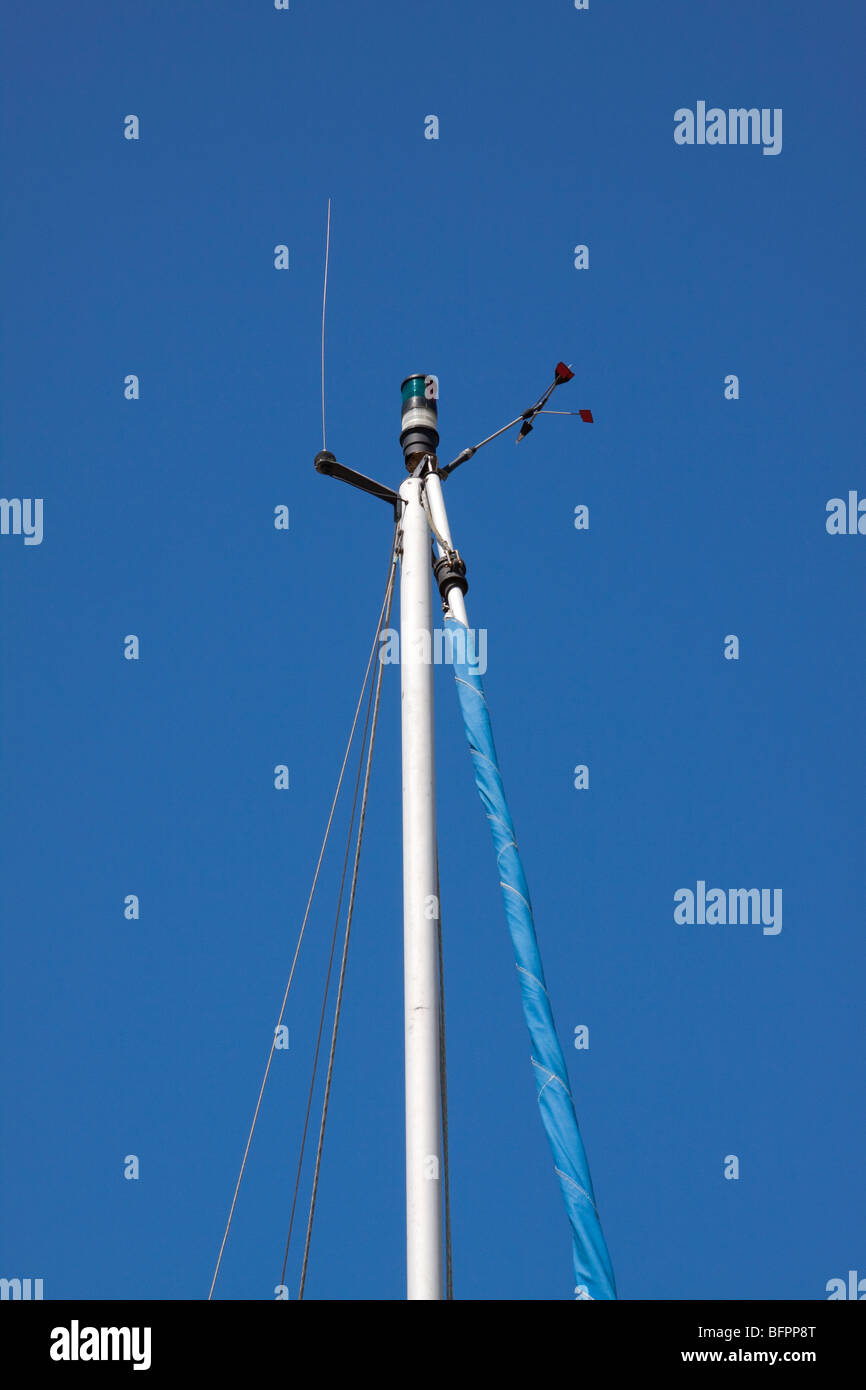 Vista ravvicinata della parte superiore di un montante di yacht che mostra la sua apparecchiatura contro un luminoso cielo blu Foto Stock