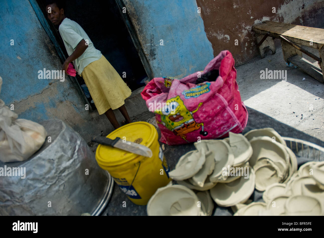 Una donna vendita torte secche realizzato a partire da una miscela di giallo sporco, acqua e sale nel cite soleil, Port-au-Prince, Haiti. Foto Stock