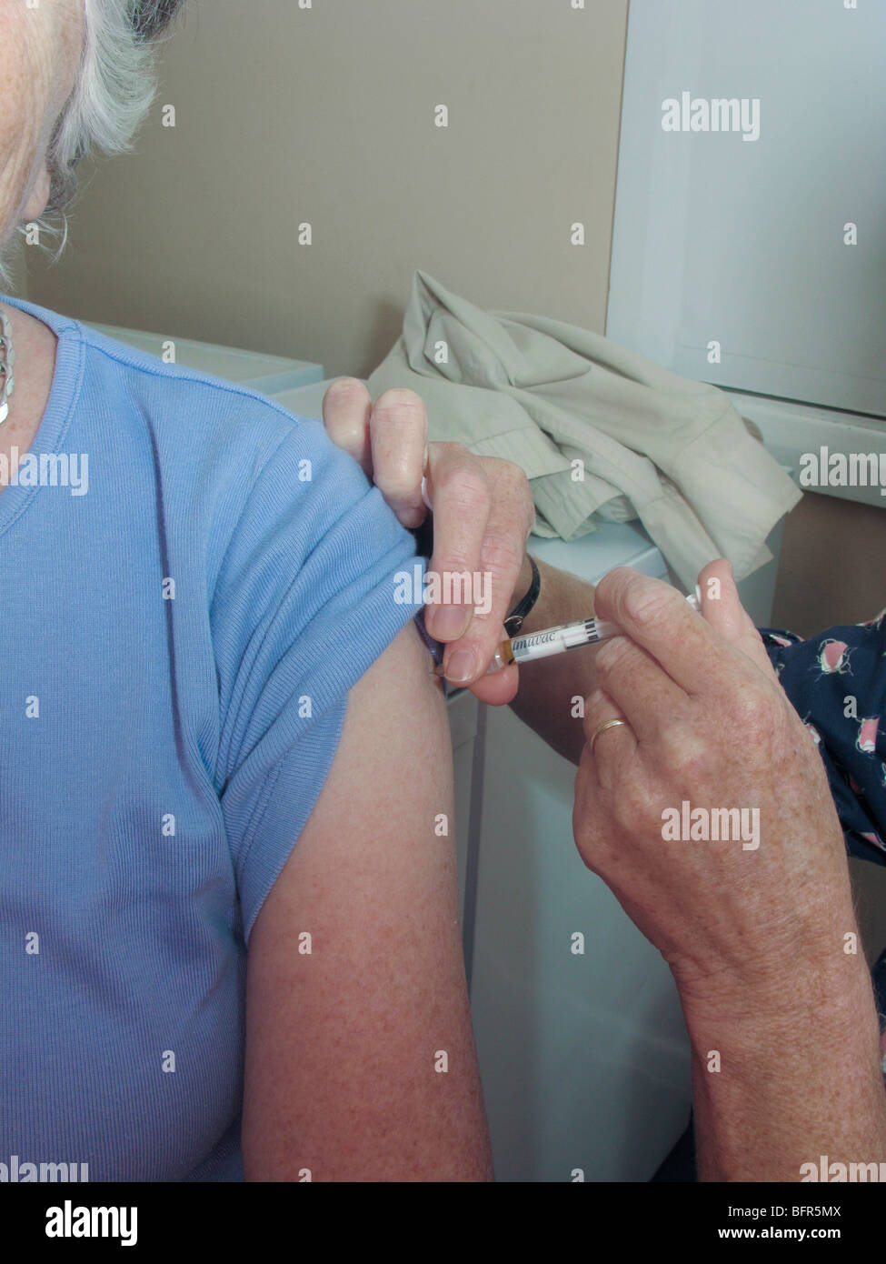 Donna anziana avente il vaccino (precauzione contro il virus invernali) Foto Stock