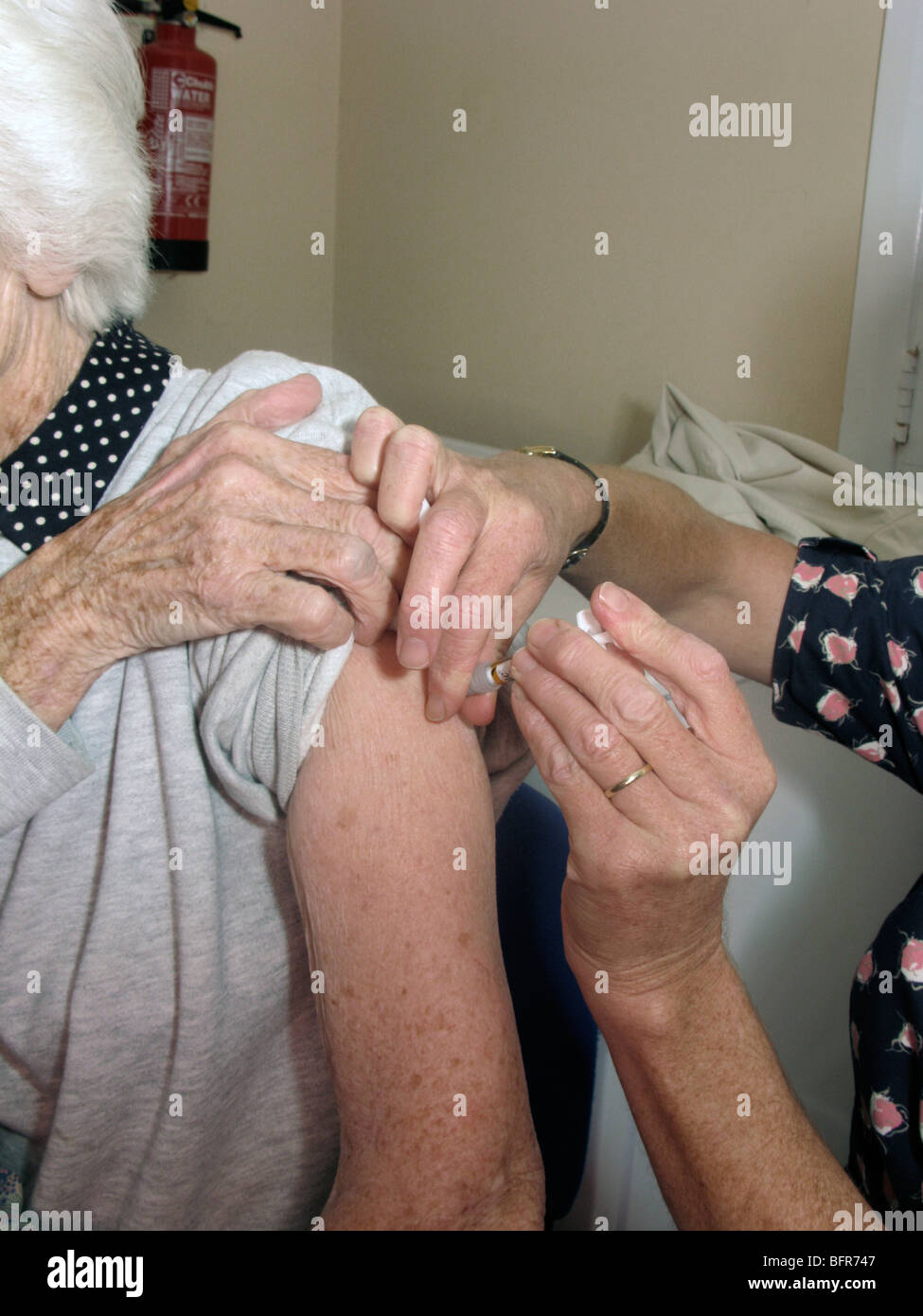 Donna anziana avente il vaccino (precauzione contro il virus invernali) Foto Stock