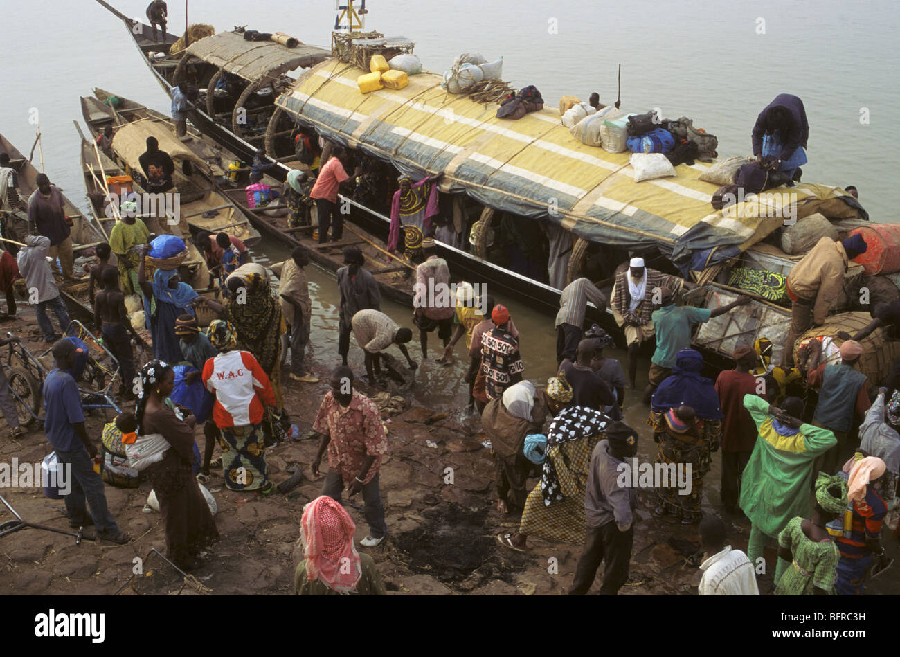 Persone sbarcate da una pinasse la principale forma di trasporto sul Fiume Niger Foto Stock