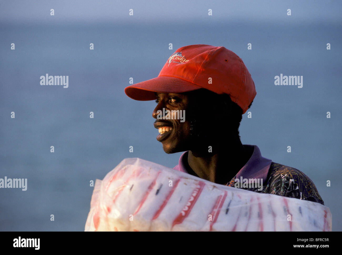 Giovane uomo che indossa un cappuccio rosso il caricamento di materiali per lodge Foto Stock