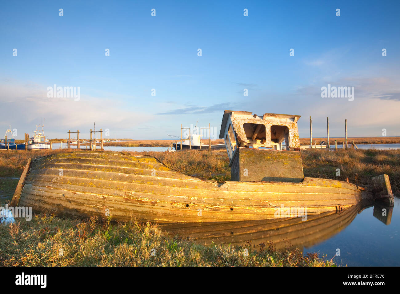 Vecchio abbandonati barca di legno a Thornham saline sulla Costa North Norfolk ad alta marea Foto Stock
