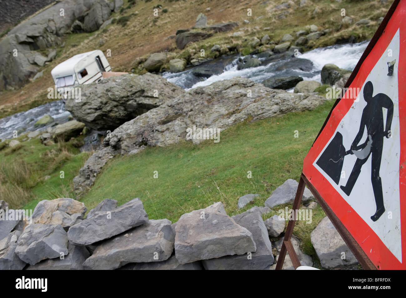 Una carovana in Llanberis Pass Snowdonia soffiata dalla strada sopra il fiume nel novembre 2009 tempeste. Foto Stock