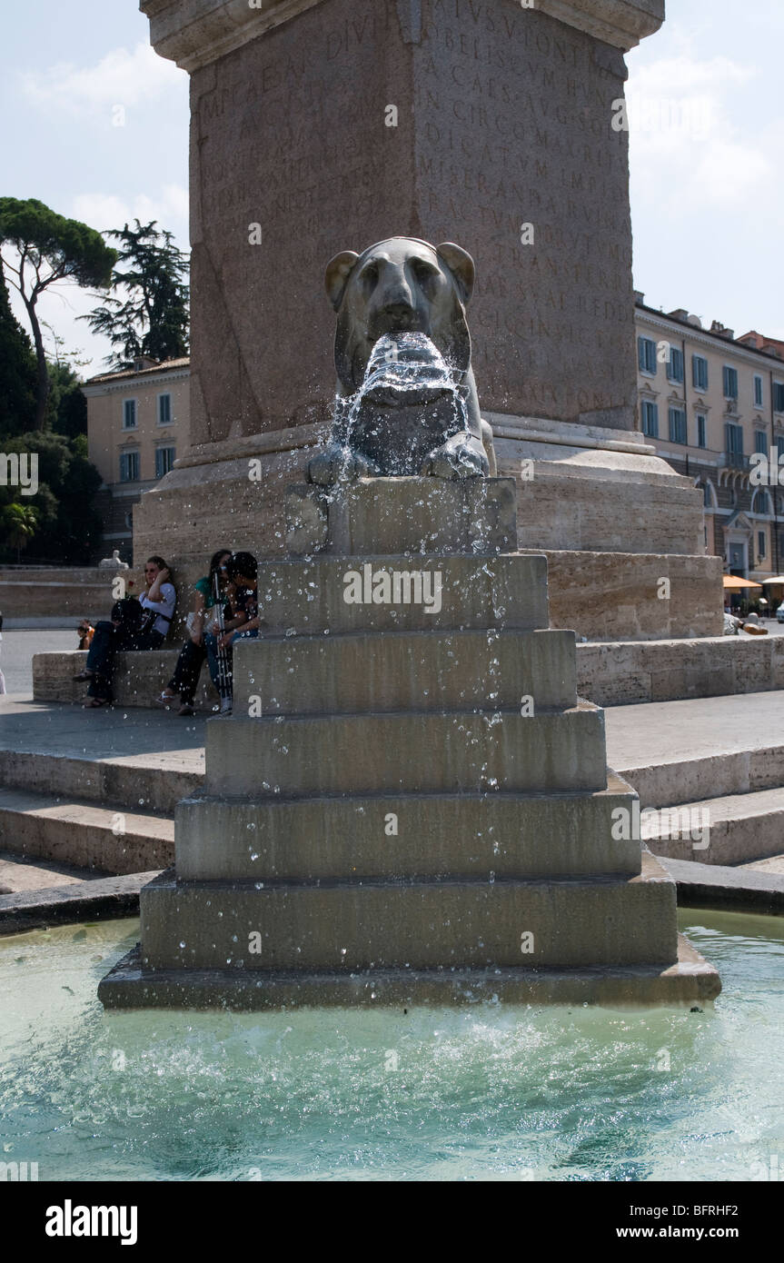 Fontana con Egyptian-style lion alla base dell'obelisco al centro di Piazza del Popolo, Roma Foto Stock