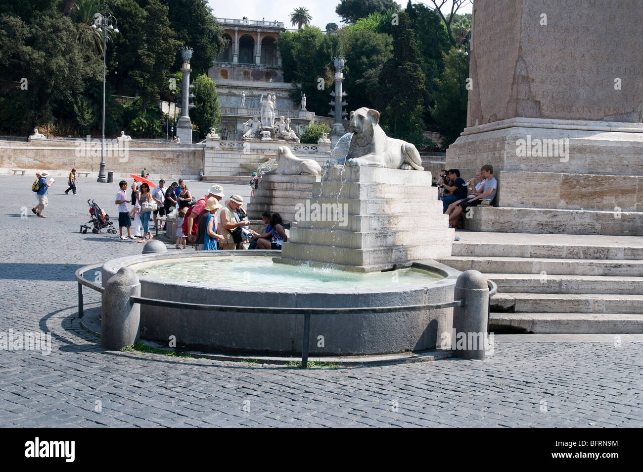 Fontana con Egyptian-style lion alla base dell'obelisco al centro di Piazza del Popolo, Roma Foto Stock