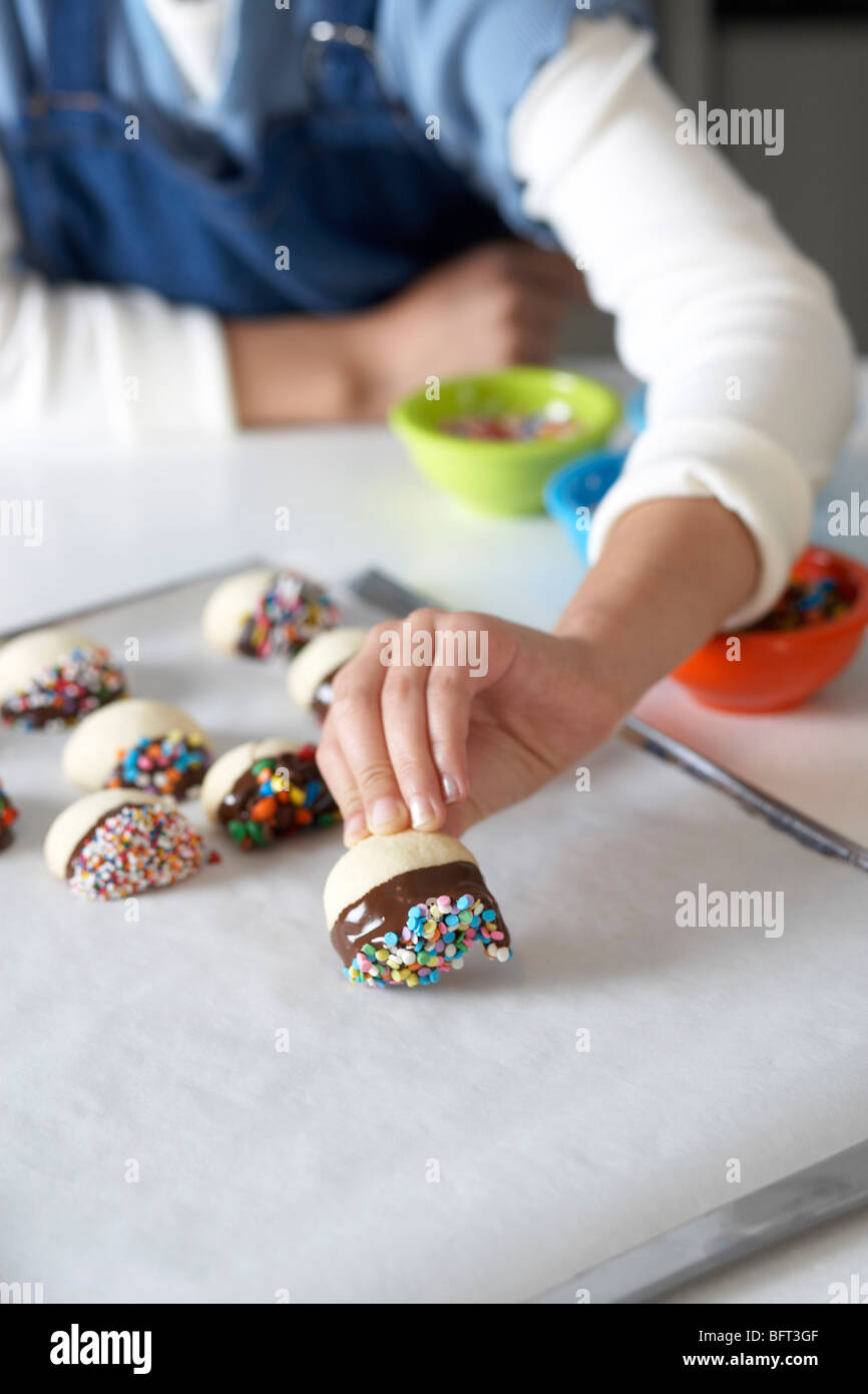 Donna che fa il cioccolato frollini anabbaglianti con un pizzico Foto Stock