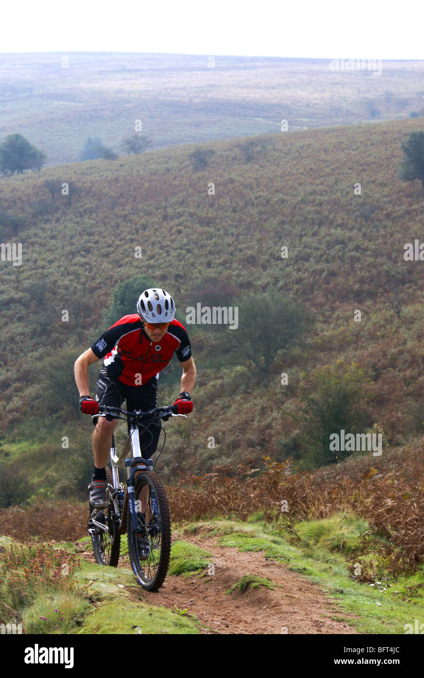 Una mountain bike si arrampica su di una ripida collina in colline di Quantock. Somerset, Regno Unito. Foto Stock