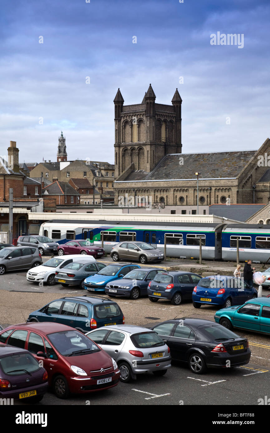 Colchester Town stazione ferroviaria formalmente noto come ST Botolphs, mostrando il parcheggio auto e St Botolph's Chiesa dietro Foto Stock