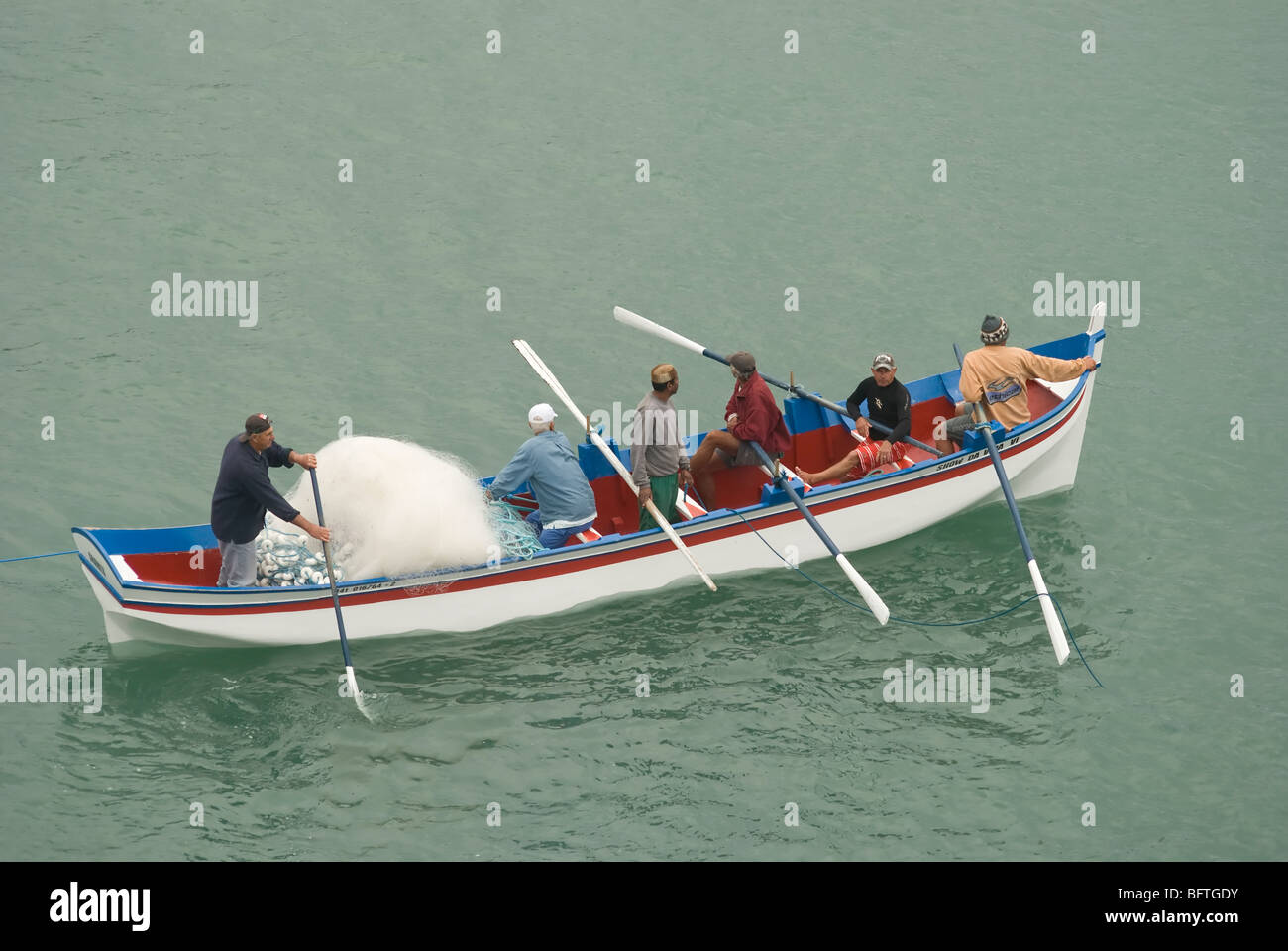 Un gruppo di pescatori all'interno di una barca durante i cefali stagione in Florianopolis. Il Brasile. Foto Stock