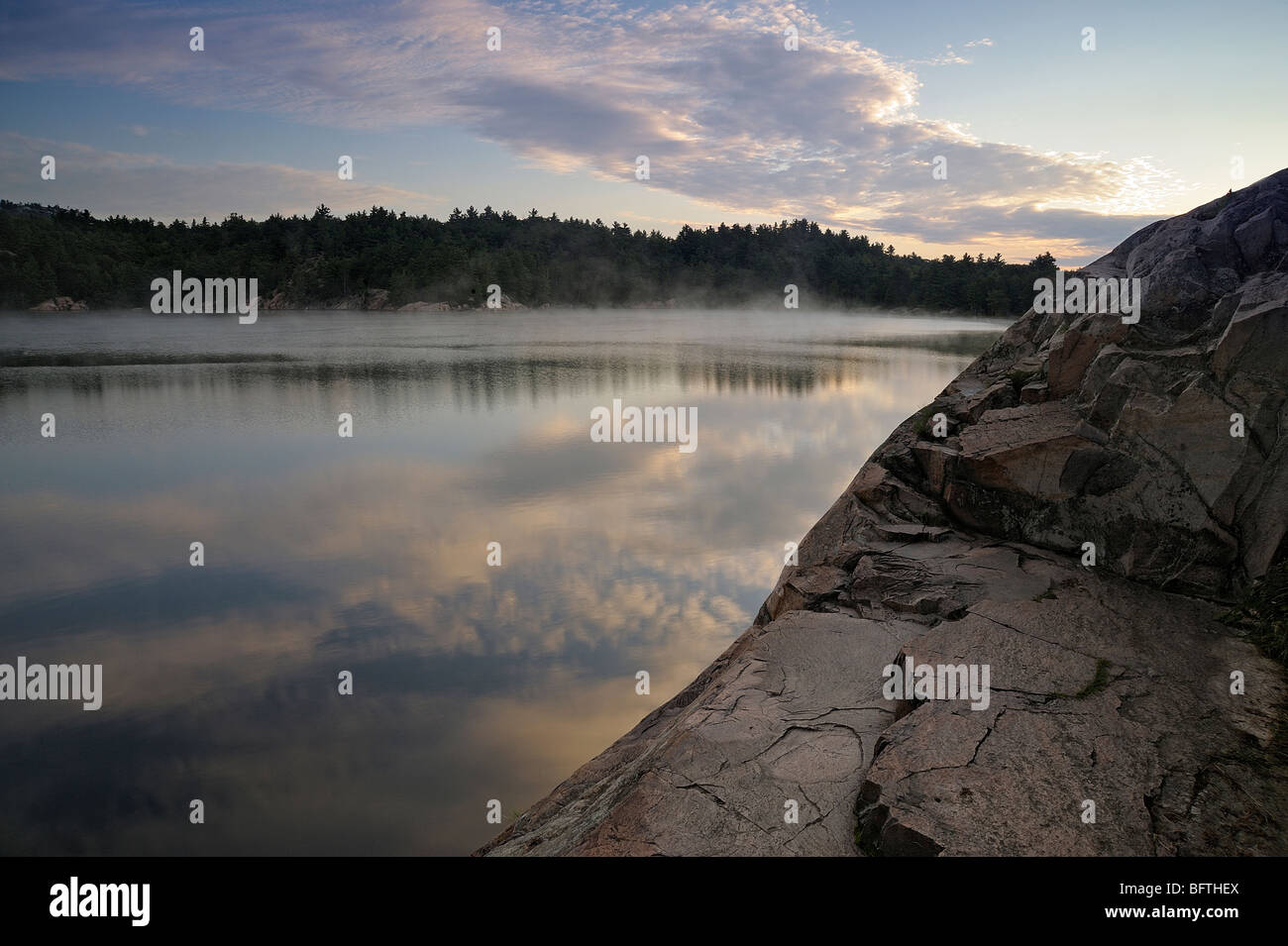 George Lago litorale scogli con predawn riflessioni in acqua, Killarney Provincial Park, Ontario, Canada Foto Stock