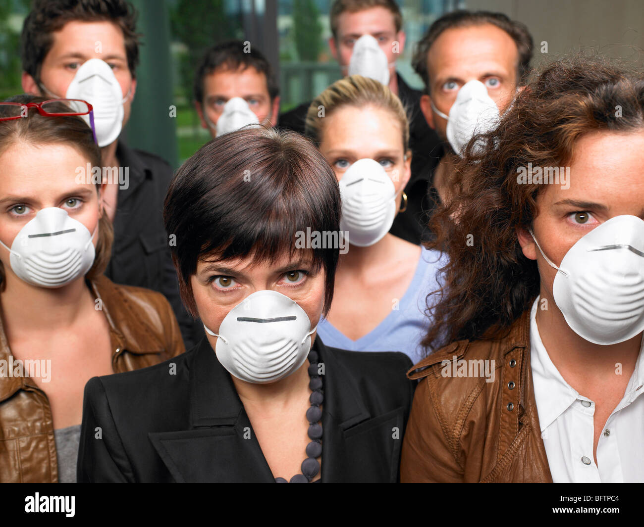 Gruppo di persone che indossano maschere di protezione Foto Stock
