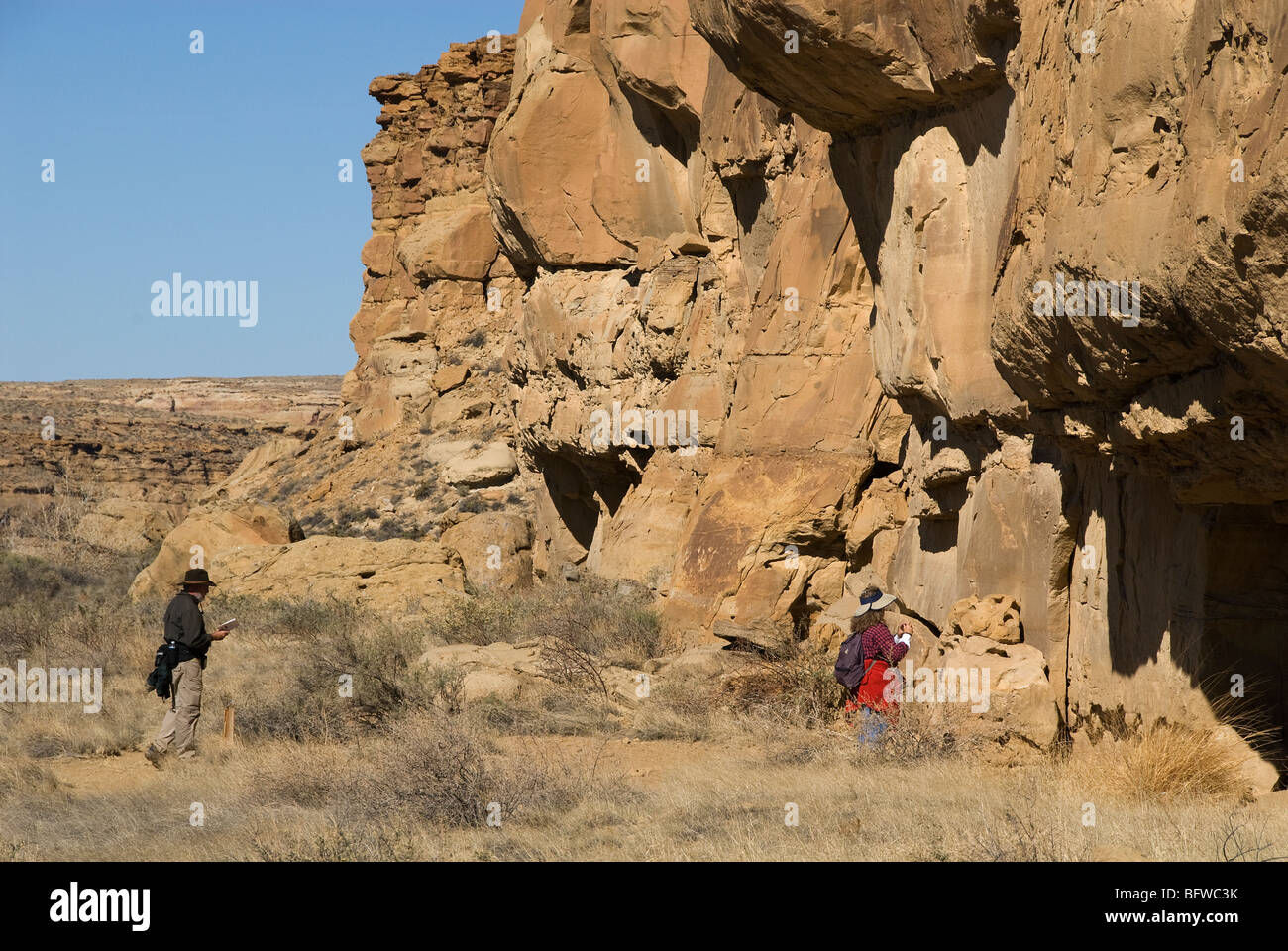 Visitatori e incisioni rupestri a nord-ovest di Casa Chiquita cultura Chaco National Historical Park Nuovo Messico USA Foto Stock