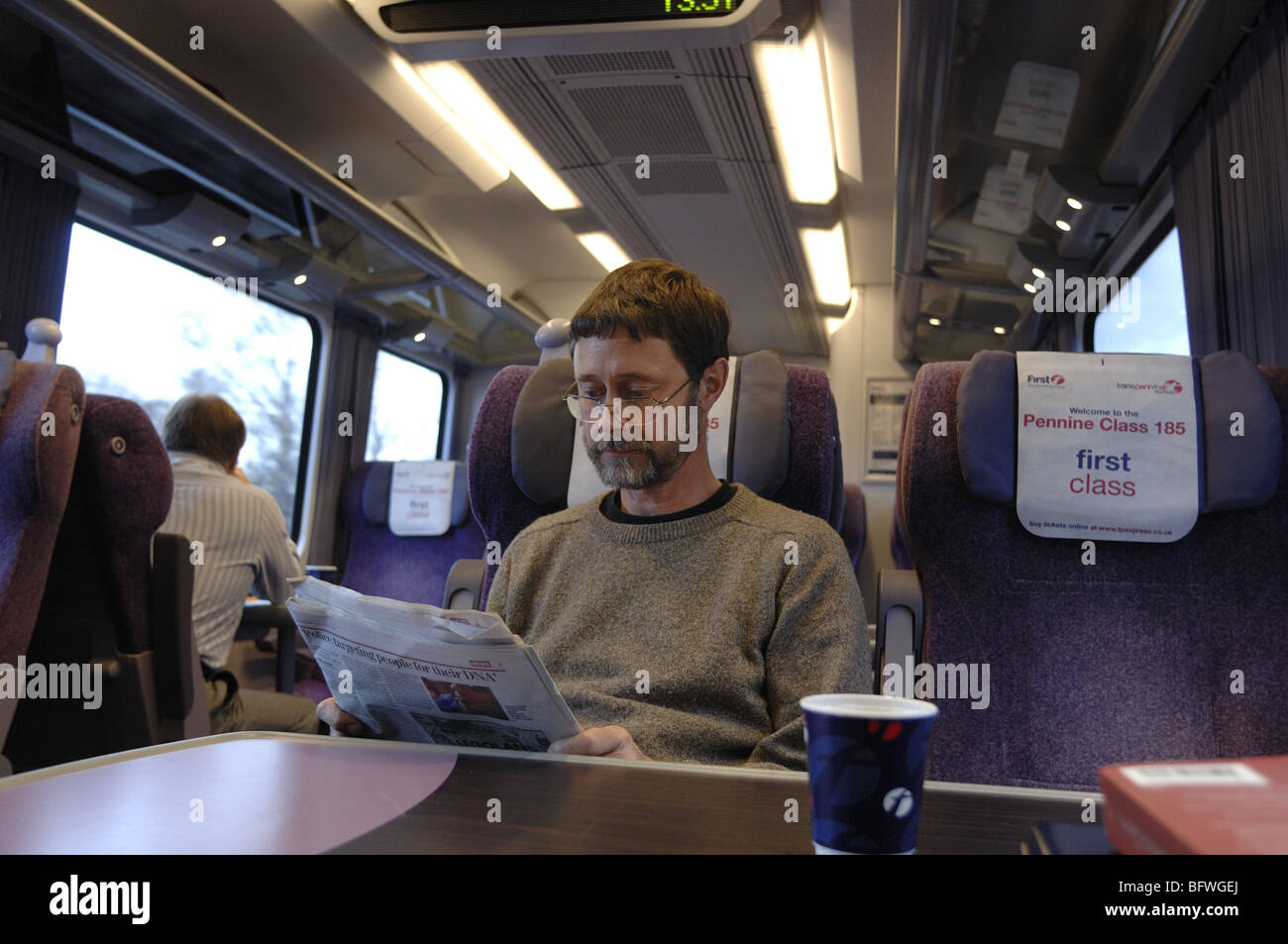Il passeggero leggendo un giornale in una prima classe carrello di un treno in Inghilterra Foto Stock