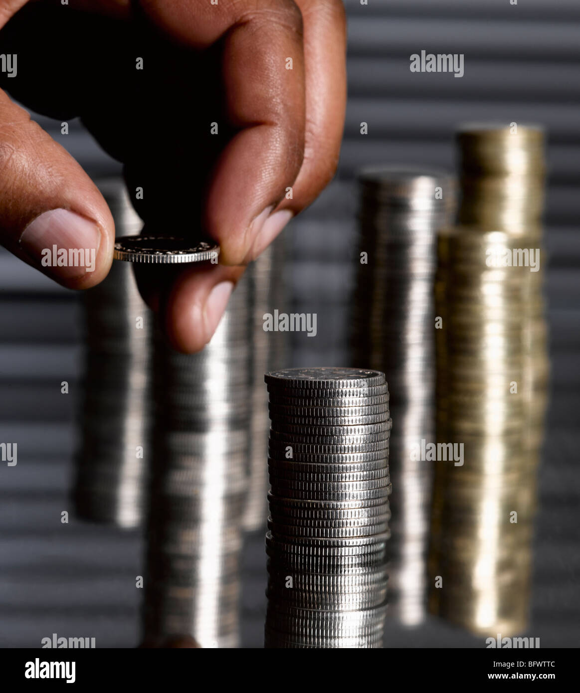 Uomo di impilamento delle monete sterlina Foto Stock