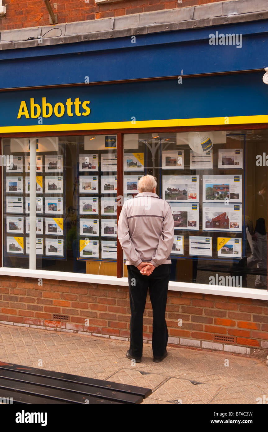 La Abati agenti immobiliari con un uomo di window shopping in high street in Halesworth,Suffolk, Regno Unito Foto Stock