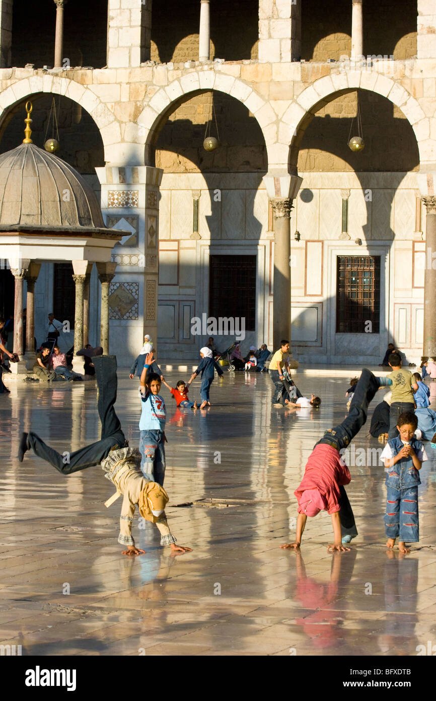 Ragazze musulmane facendo capriole in moschea degli omayyä a Damasco in Siria Foto Stock