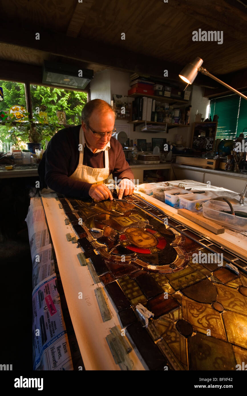 Artigiano di talento la riparazione di una macchia di finestra in vetro Foto Stock