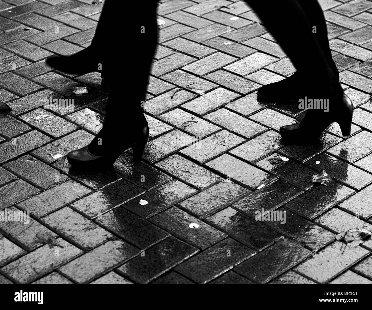 Due donne a piedi sotto la pioggia Foto Stock