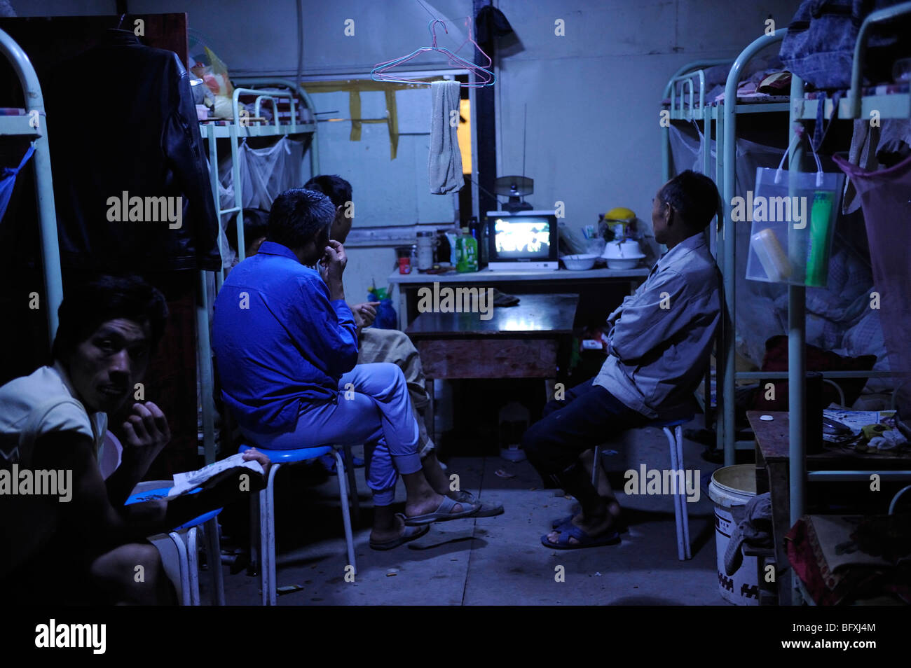 Lavoratori cinesi guardando la TV in un dormitorio in costruzione sito del World Expo 2010 a Shanghai in Cina.15-ott-2009 Foto Stock