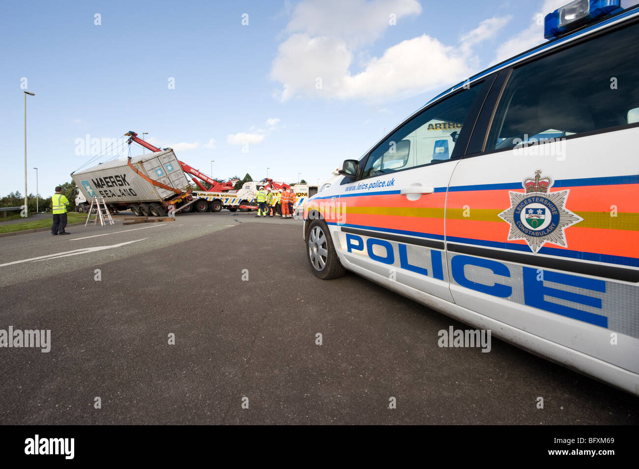 Autocarro ribaltata essendo salvato da un carrello di salvataggio nel Leicestershire, in Inghilterra con auto della polizia sul sito Foto Stock