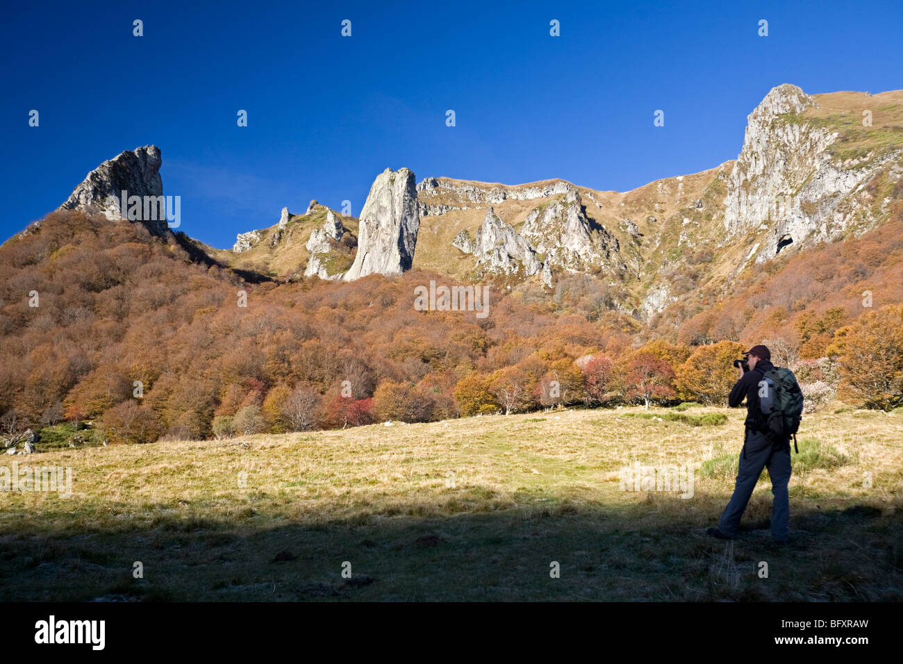Un escursionista fotografare la valle di Chaudefour, in autunno (Francia). Randonneur photographiant la vallée de Chaudefour, en automne. Foto Stock