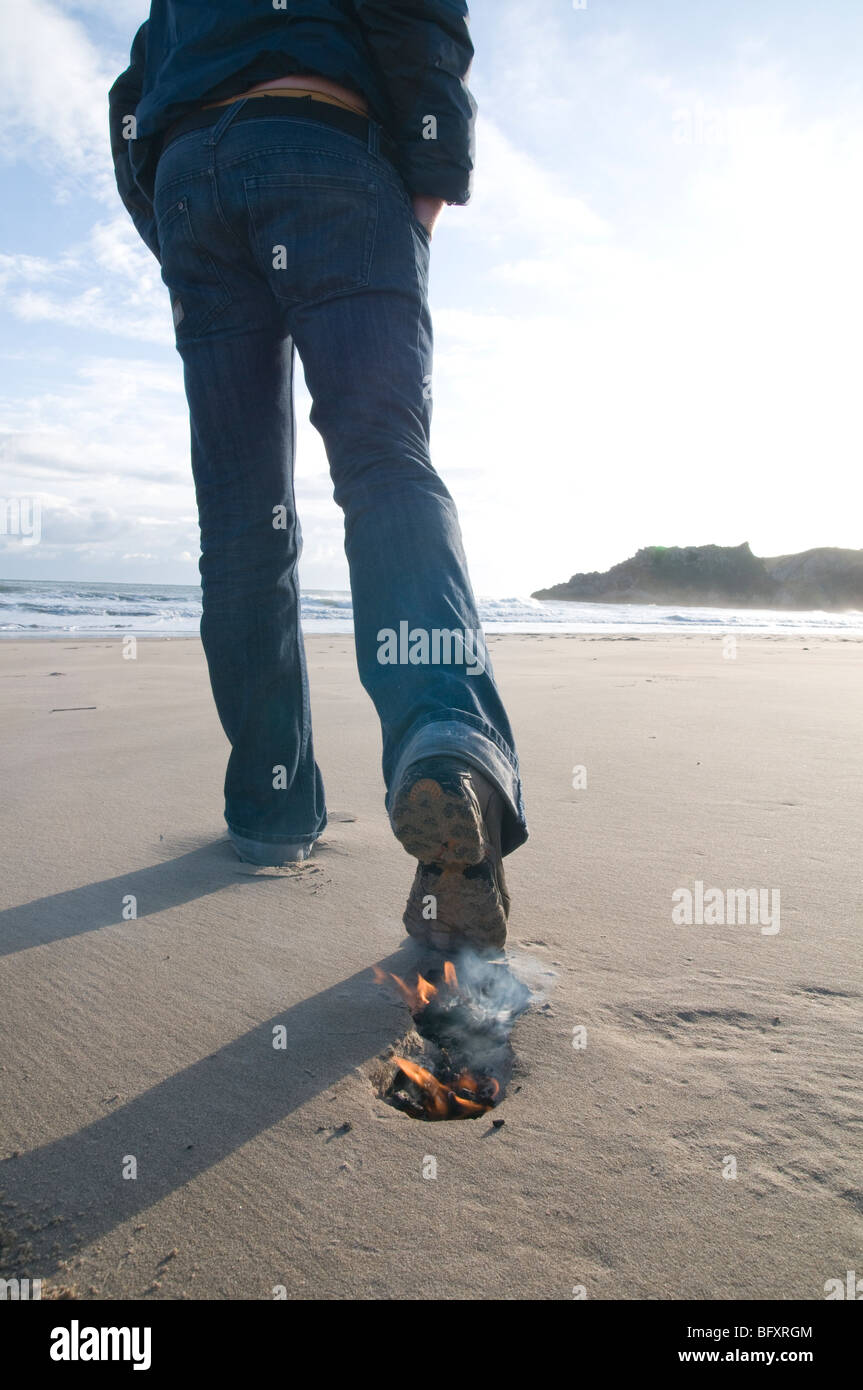 Piede di carbonio stampa, foot print sul fuoco, blackend sulla spiaggia Foto Stock