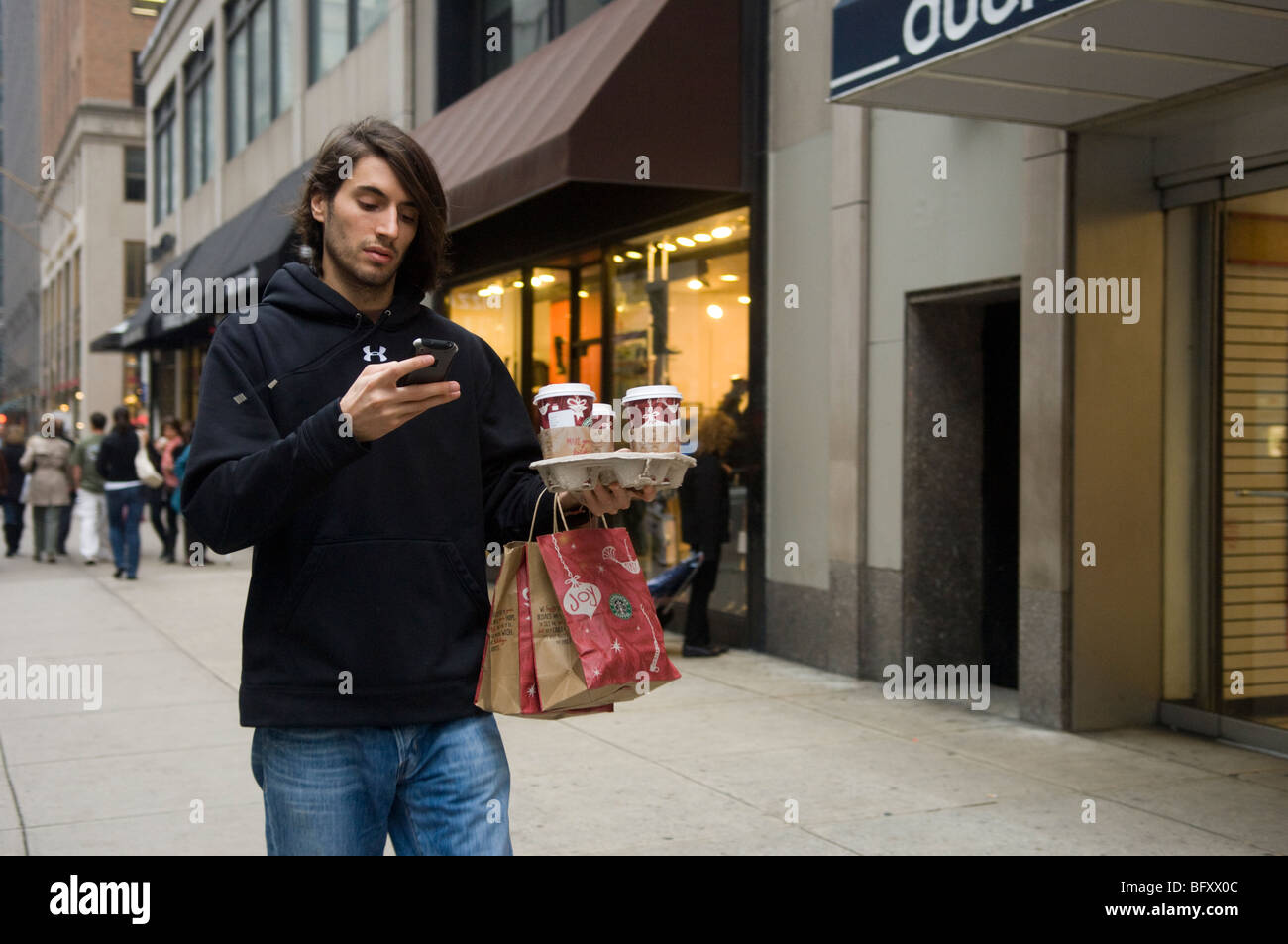 Un cliente porta estrarre caffè Starbucks sulla Fifth Avenue a Midtown a New York Foto Stock