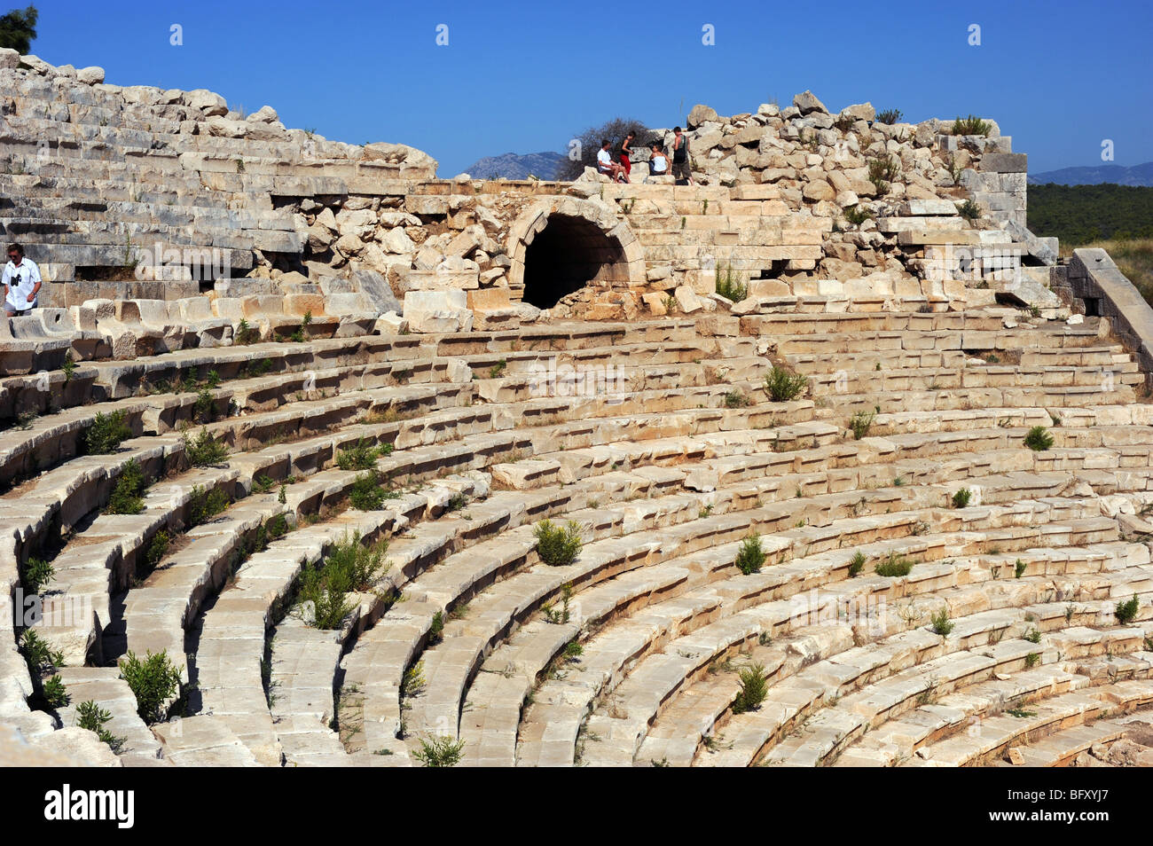 I turisti in cerca di tutto il antico anfiteatro in rovine a Patara Foto Stock