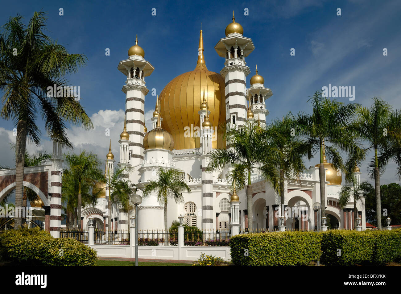 Golden Dome & minarets of Masjid Ubudiah or Ubudiah Royal Mosque (1917) di Arthur Benison Hubbback incorniciata da palme Kuala Kangsar, Perak, Malesia Foto Stock