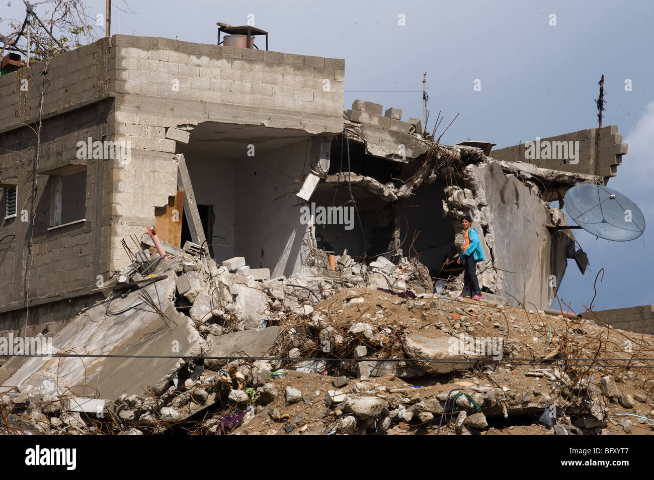 Una ragazza sorge sulle rovine della sua casa di Jebaliya nord della striscia di Gaza dopo il 2009 Israele guerra. Foto Stock