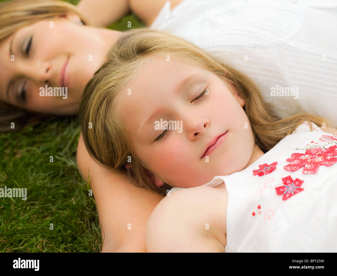 Una madre e figlia giacente su un prato Foto Stock