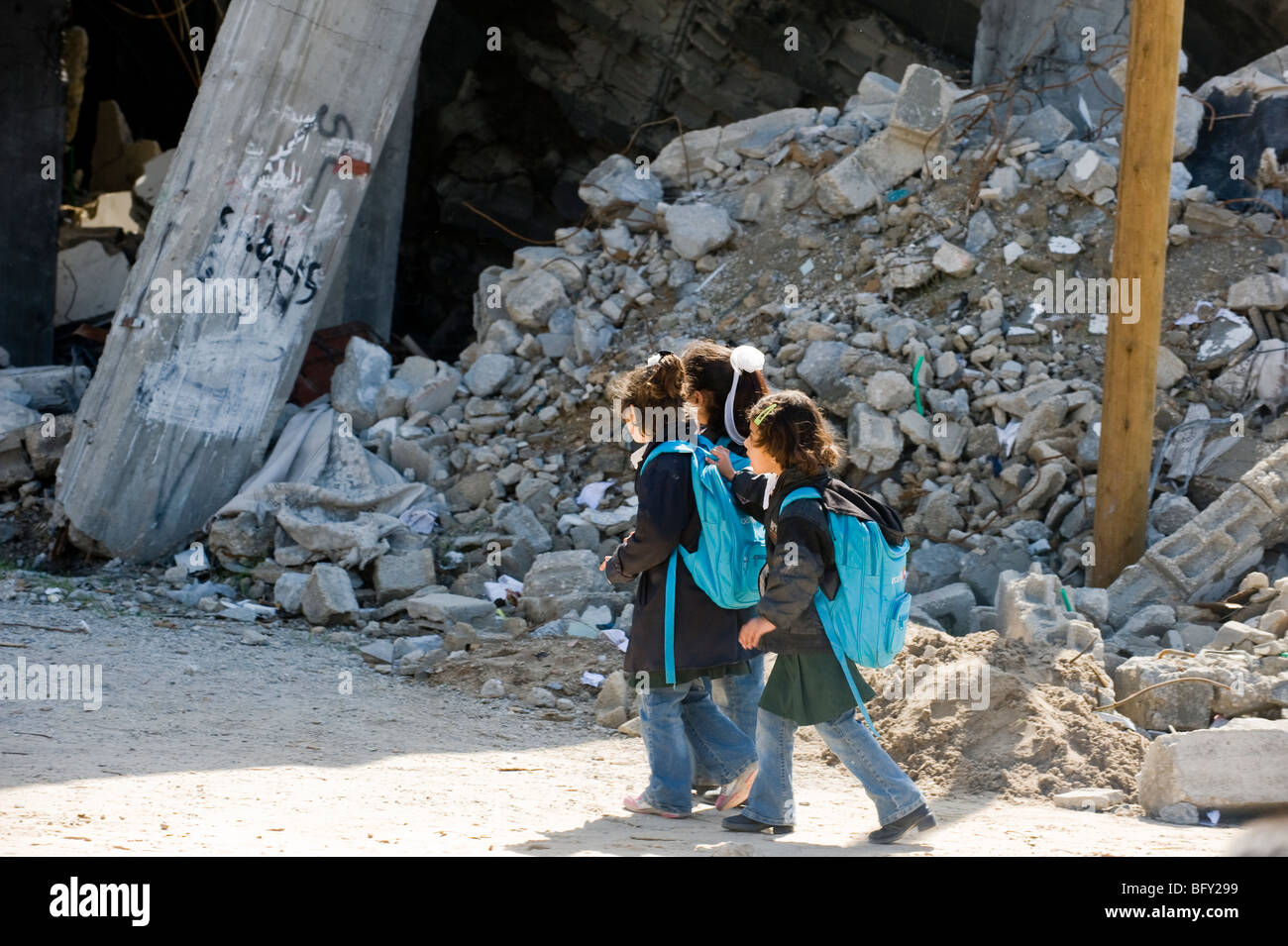 Bambini palestinesi lasciare la scuola UNRWA intorno a macerie a sinistra dopo la guerra israeliana nella Striscia di Gaza nel gennaio 2009. Foto Stock