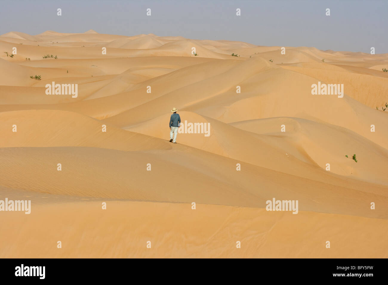 Tourist camminare da solo nel deserto in Chinguetti in Mauritania Foto Stock