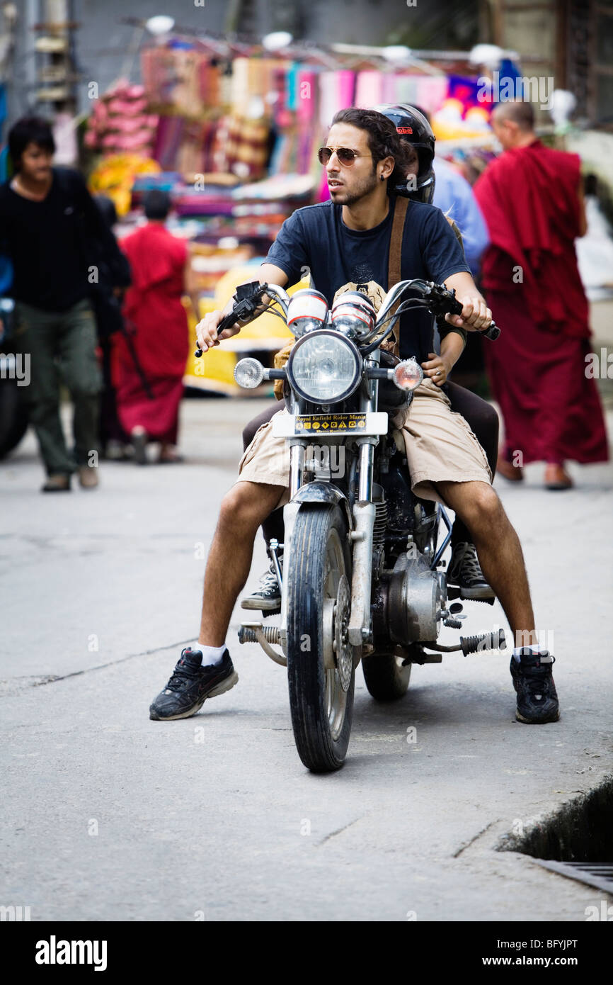 Un backpacker con un affittato Royal Enfield moto in Dharamsala, India. Foto Stock