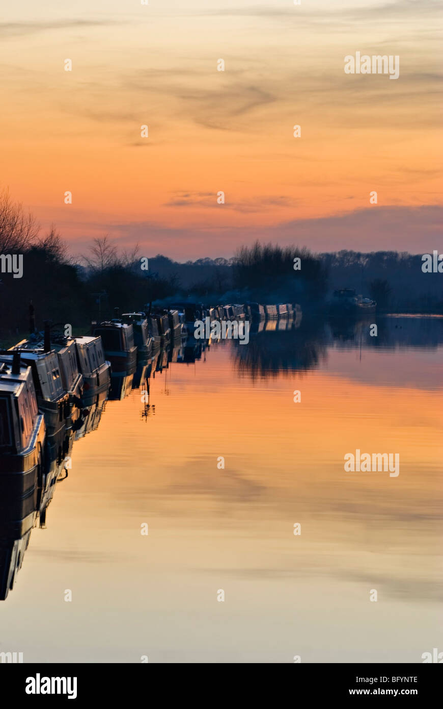 Battelli con riflessione e arancione tramonto a Gloucester & Nitidezza canale e su una bellissima serata ancora, prese a Slimbridge Foto Stock