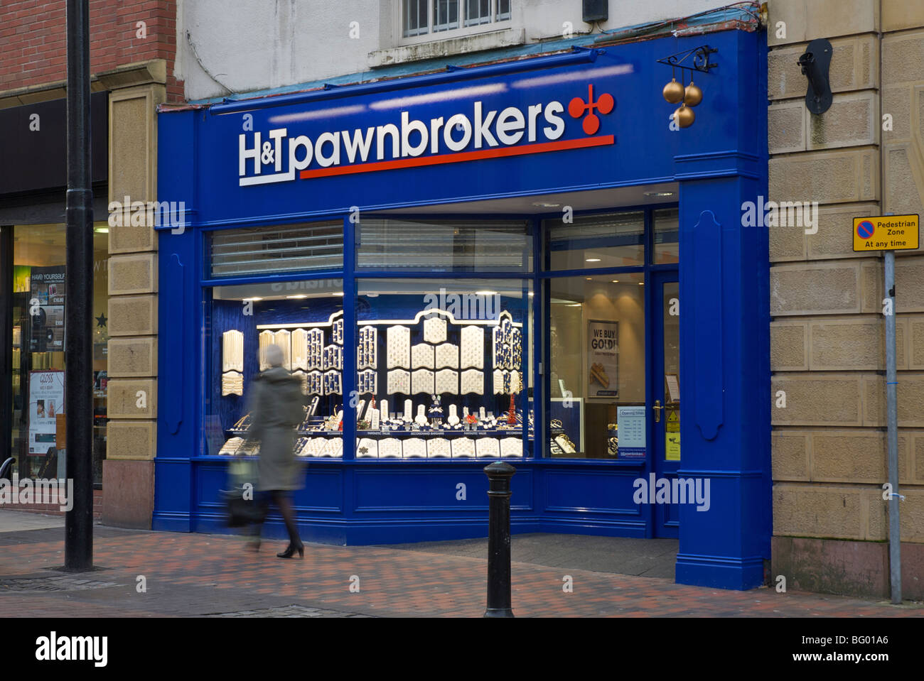 Donna passato a piedi H & T Pawnbrokers, Preston, Lancashire, Inghilterra, Regno Unito Foto Stock