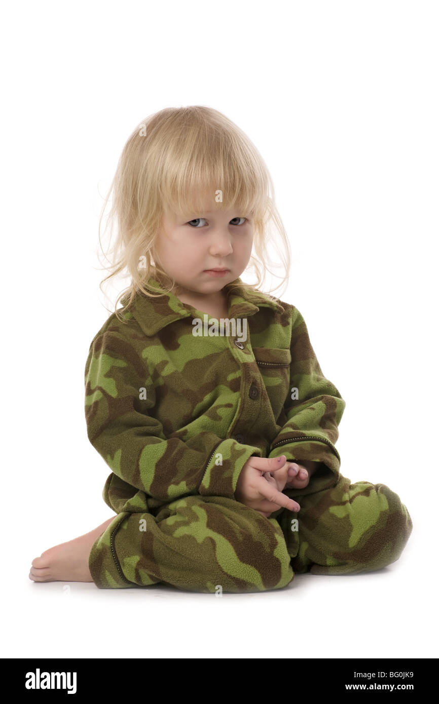 Divertente seduta carino bambina in stile militare pigiami isolato su bianco Foto Stock