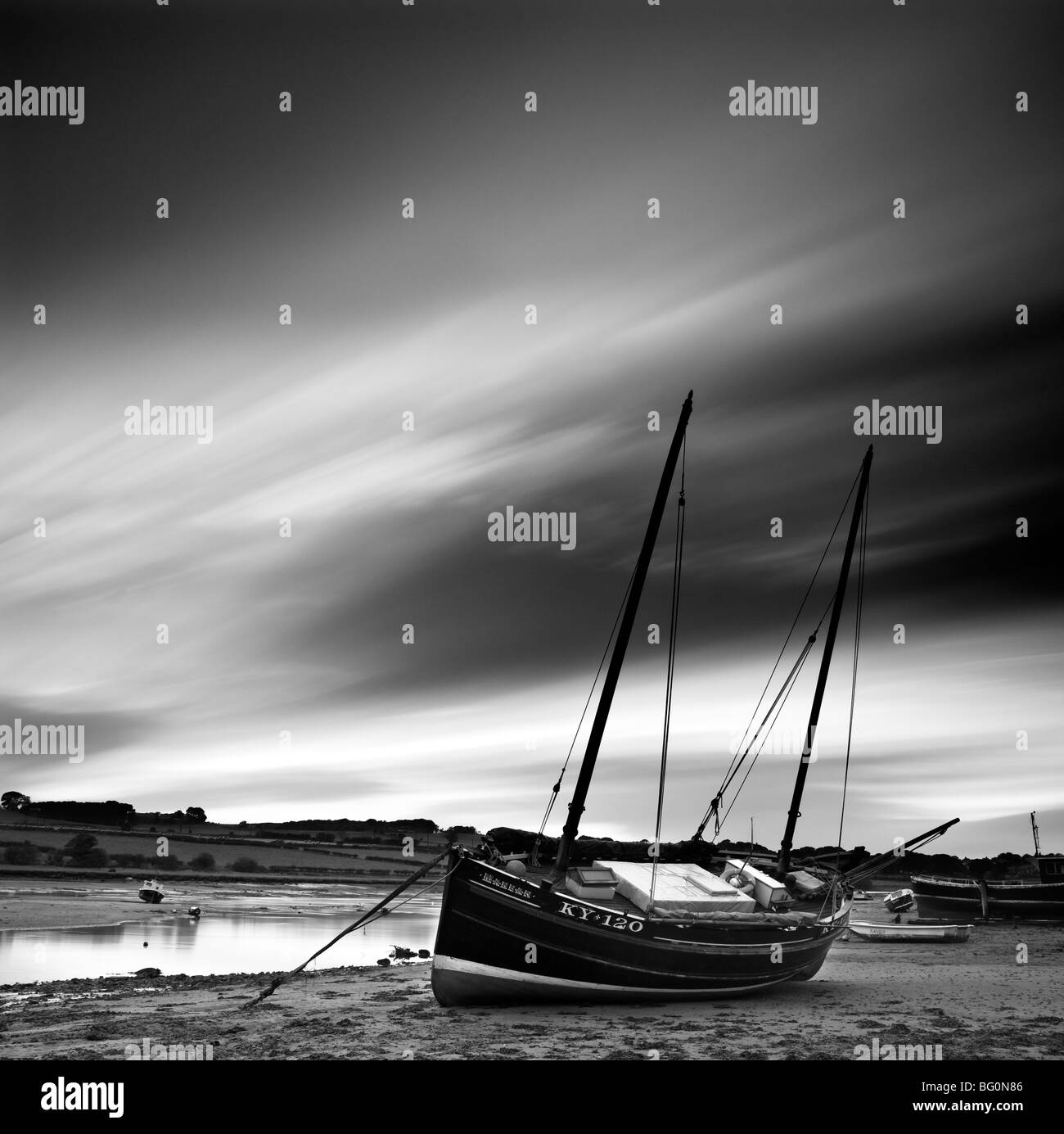 Una lunga esposizione di mobili nuvole e vecchio ketch in legno, Aln Estuary a bassa marea, Alnmouth, Alnwick, Northumberland, Regno Unito Foto Stock