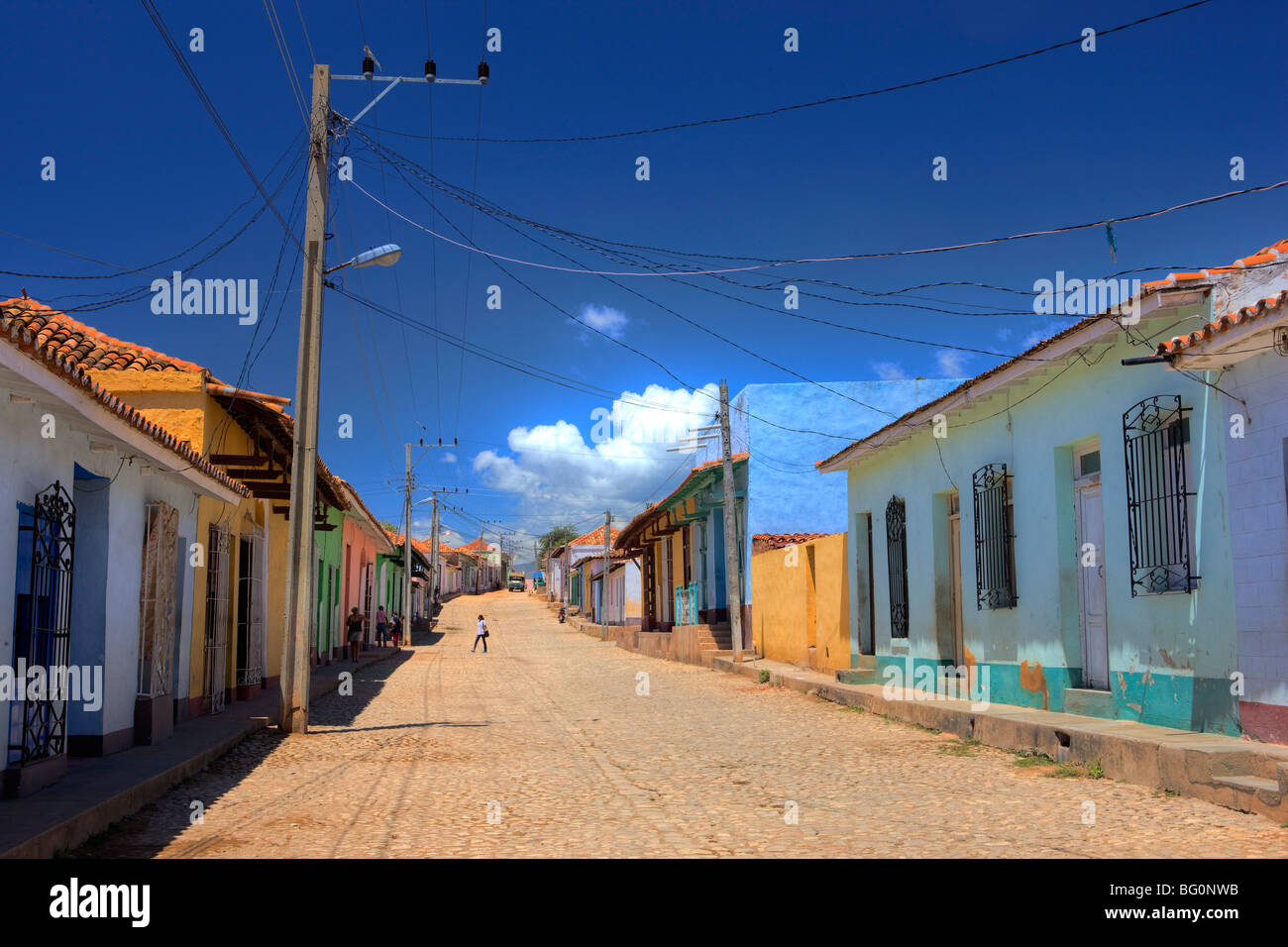 Vista lungo la strada di ciottoli rivestiti con luminosi-case dipinte, Trinidad, Cuba, West Indies, America Centrale Foto Stock