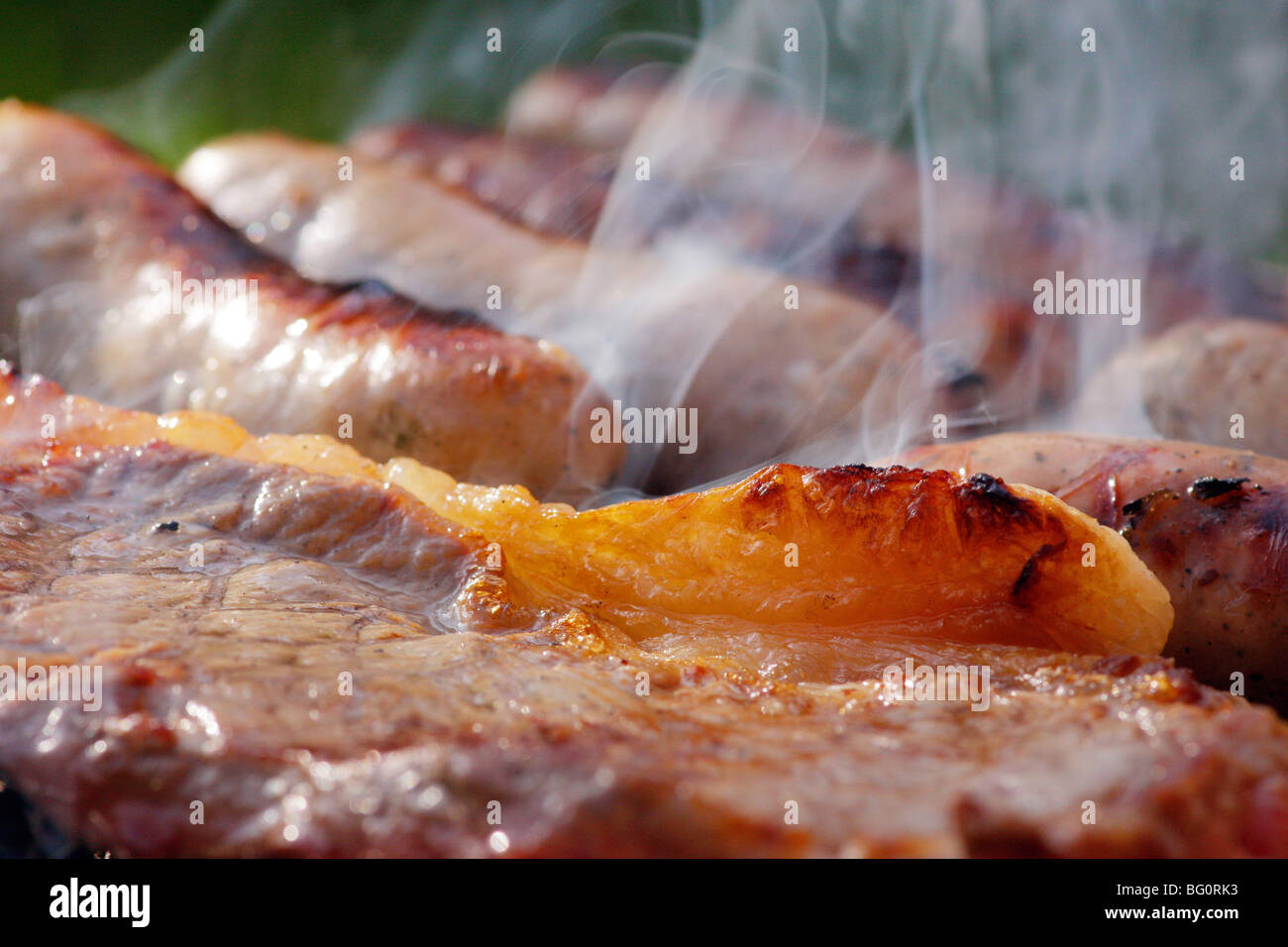 Bistecche e salsicce cottura su un barbecue Foto Stock