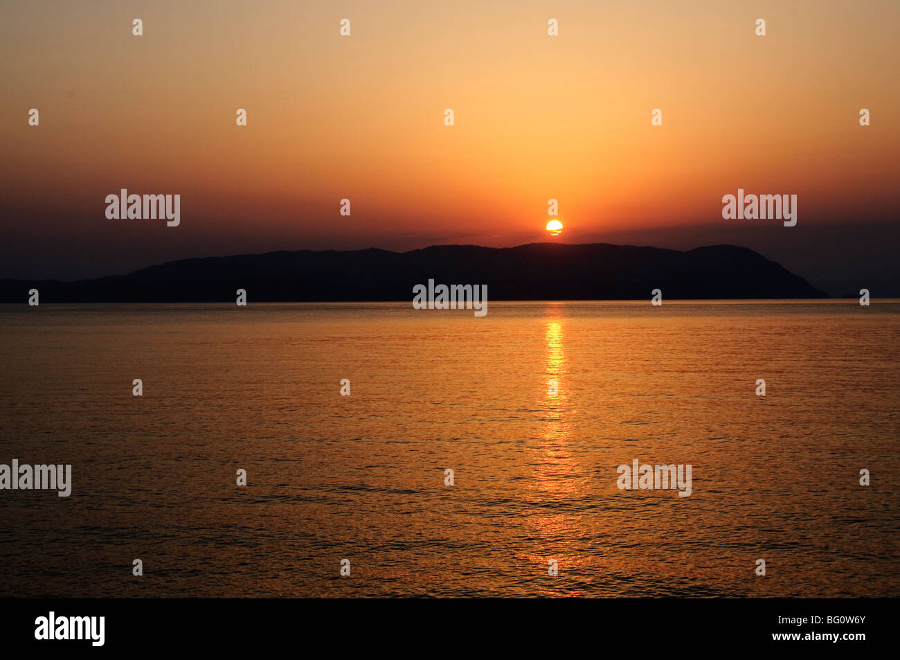 Tramonto sul Mar Egeo, preso da Loutraki Skopelos, con Skiathos in background, Isole Sporadi, isole greche, Grecia Foto Stock