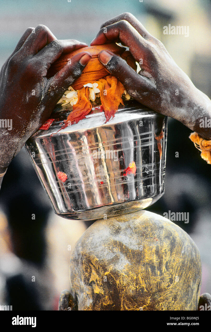 Un pellegrino/devoto porta un'offerta all'Palani Murugan Temple e sta prendendo parte al festival di Thaipusam per onorare il Signore Subramaniam (noto anche come Signore Muruga), figlio di Shiva. L'offerta bilanciata sulla sua testa è una forma di kavadi e simboleggia l'onere che egli porta per mostrare la sua devozione. Migliaia di indù come questo uomo venuto a cercare la penitenza e assoluzione per i peccati passati e mostrare gratitudine a Dio per le benedizioni durante l'anno Foto Stock