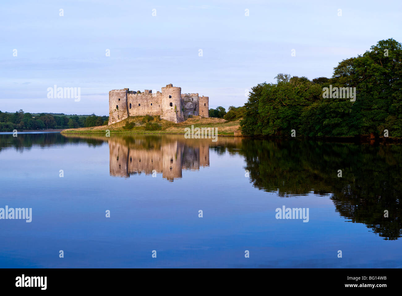 L'ultimo della sera che riflette la luce solare off Carew Castle accanto al fiume Carew a Carew, Pembrokeshire, Galles Foto Stock