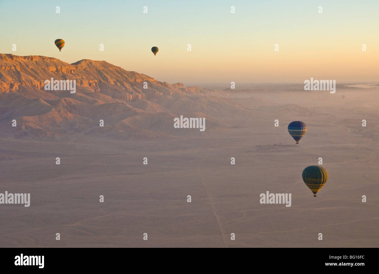 I palloni ad aria calda volando sul deserto all'alba sulla sponda ovest del Nilo vicino a Luxor, Egitto, Nord Africa Foto Stock