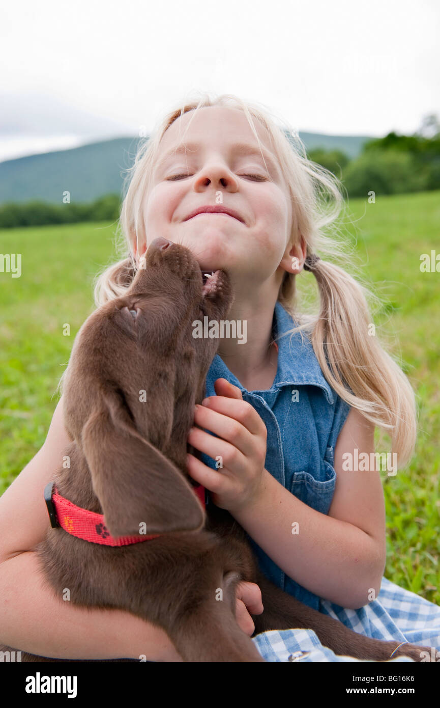 Giovane ragazza che abbraccia il suo cucciolo Foto Stock