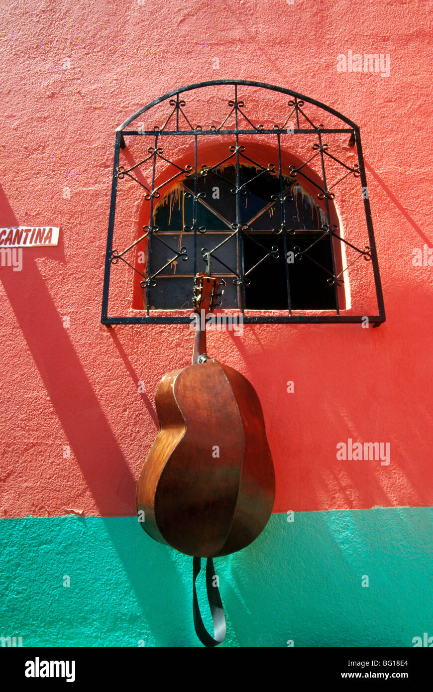 Un violoncello pende dalla finestra di una cantina in San Andre Itzapa, Guatemala come la band si prende una pausa durante il mese di ottobre annuale Fiesta de Rilaj Maam (Maximom) Foto Stock