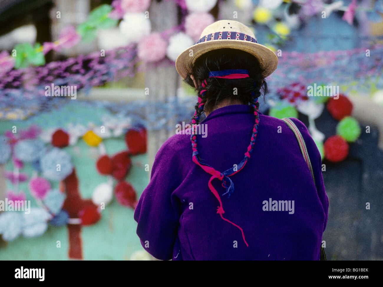 Il rispetto è pagato e i membri della famiglia onorato da una donna che ha dato marcatori e lapidi che sono state decorate per il Giorno dei Morti festival a Todos Santos, Guatemala Foto Stock